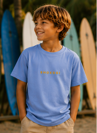 Boy wearing a Carolina Blue SHOKOGI kids t-shirt with SHOKOGI chest logo at Playa Venao beach